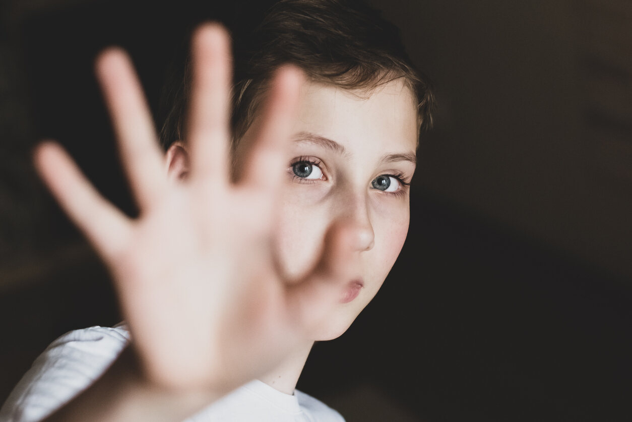 Child with hand extended, signaling 'stop', symbolizing refusal of visitation.