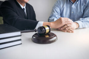 Image of Male lawyer or judge help encourage client, customer, working with gavel and Law books, report the case on table in modern office, Law and justice concept