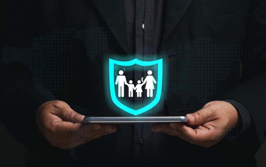 A person in a dark suit holding a tablet displaying a glowing digital shield icon with a family inside, symbolizing family protection and custody rights in Los Angeles County juvenile dependency and private custody cases.